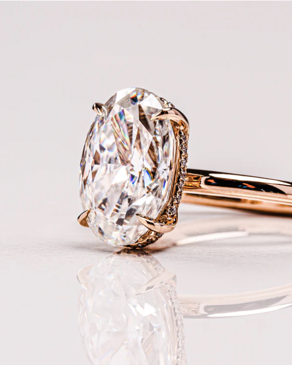 Detalle de anillo oval 2.00 ct con banda delgada y engaste clásico en oro.