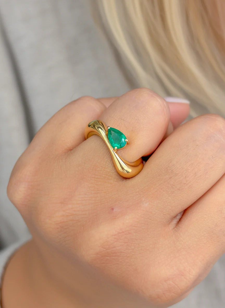 Anillo contemporáneo abierto con esmeralda verde lab-grown y diseño orgánico en oro sólido.