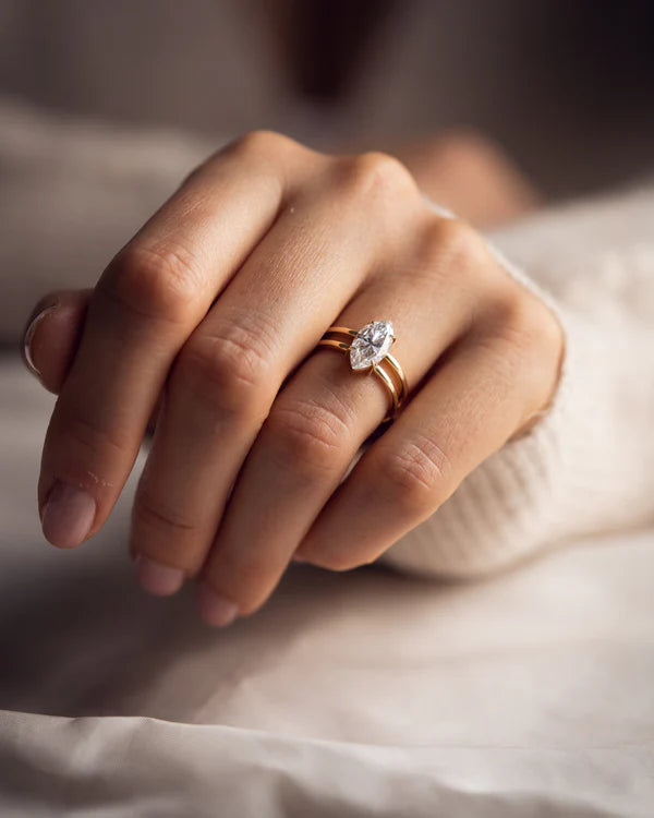 Detalle de anillo marquise 2 ct con doble banda y engaste de garras en oro.