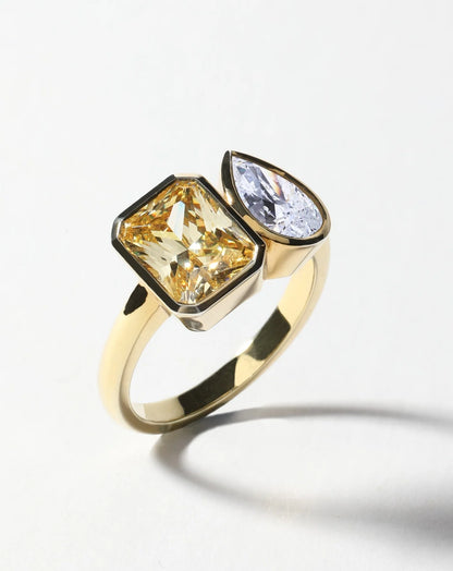 Detalle de anillo Toi et Moi con diamantes lab-grown en cortes emerald y pear con engaste bezel.