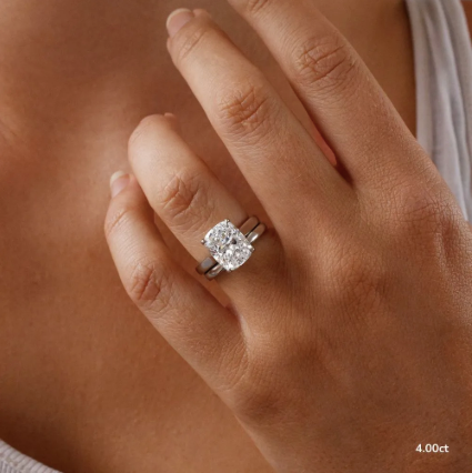 Detalle de diamante incoloro corte cushion 4.00 ct montado en anillo de compromiso minimalista.
