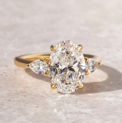 Anillo de compromiso con diamante de laboratorio 3.00 ct corte oval y dos diamantes laterales en oro.