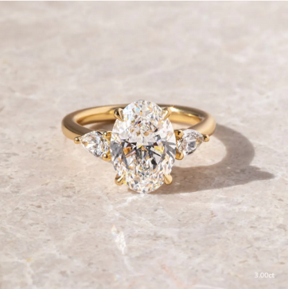 Anillo de compromiso con diamante de laboratorio 3.00 ct corte oval y dos diamantes laterales en oro.