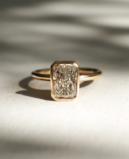 Anillo de compromiso con diamante de laboratorio 1.50 ct corte emerald en engaste bezel de oro.