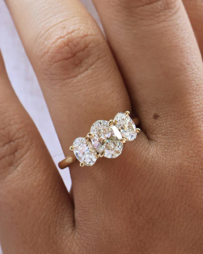Anillo de compromiso con diamantes de laboratorio corte oval, centro de 1.50 ct y dos piedras laterales de 0.70 ct en oro.