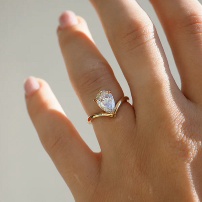 Detalle de anillo pear 2.00 ct con diseño abierto en V y engaste de garras en oro.