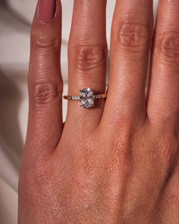 Detalle de anillo oval 1 ct con pavé lateral y engaste de cuatro garras.
