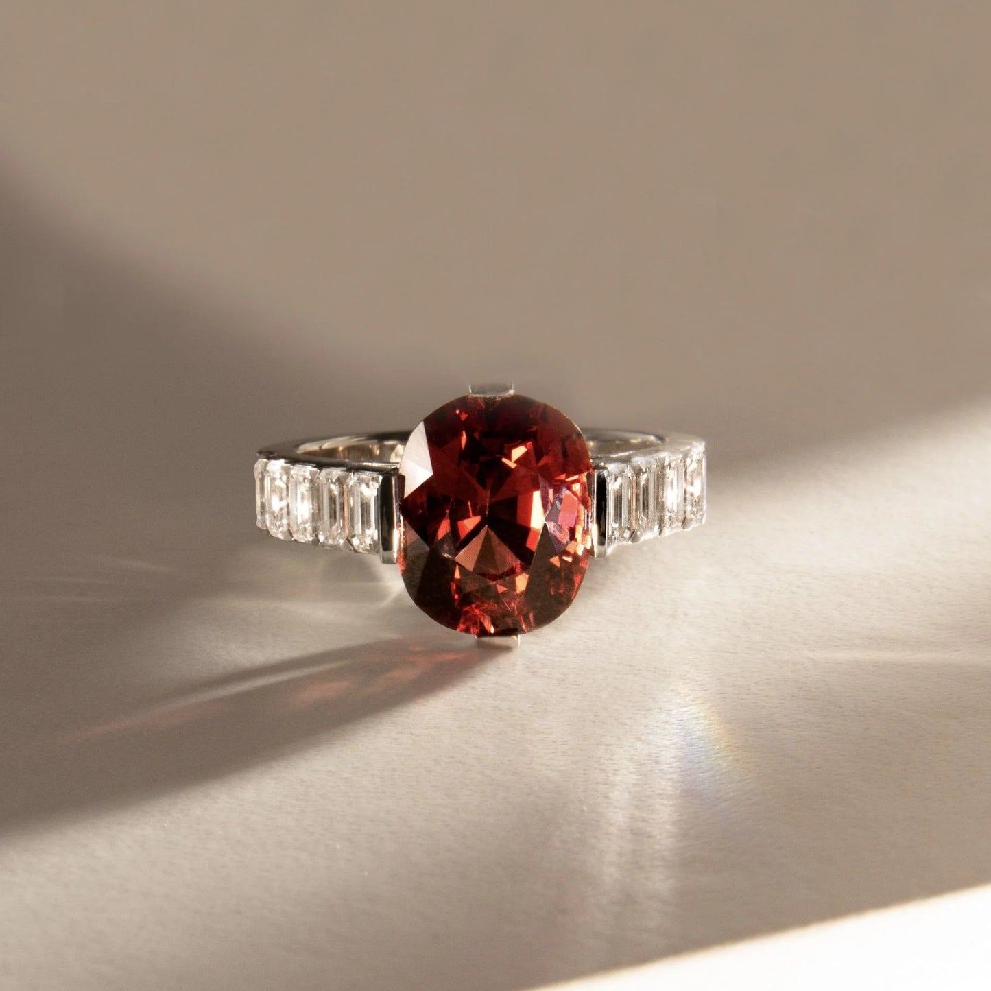 Anillo de compromiso con lab-grown diamond fancy rojo 2.00 ct corte oval y diamantes baguette laterales.
