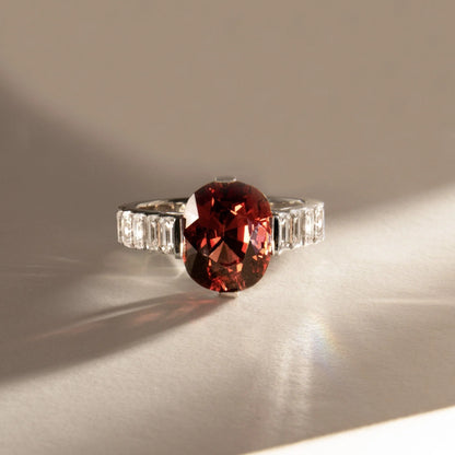 Anillo de compromiso con lab-grown diamond fancy rojo 2.00 ct corte oval y diamantes baguette laterales.