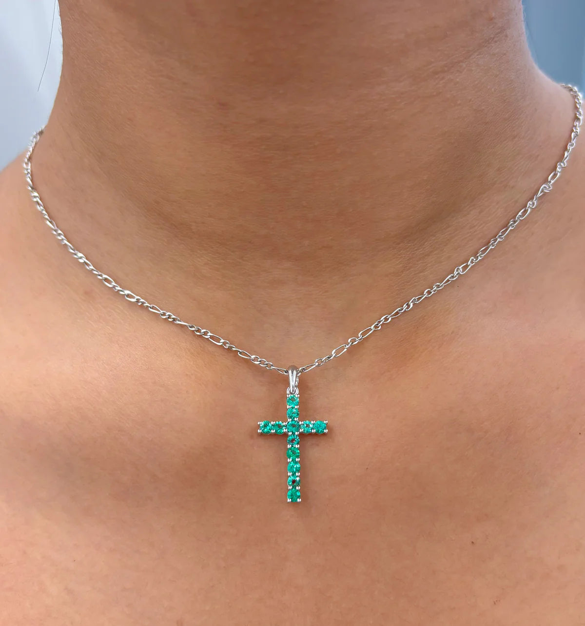Cruz de oro 14K con esmeraldas lab-grown redondas color verde intenso.