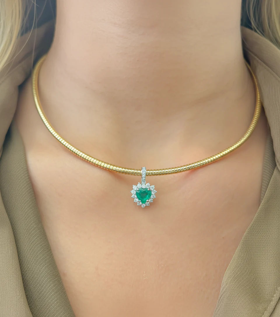 Dije corazón de esmeralda lab-grown verde con halo brillante de diamantes en oro amarillo.