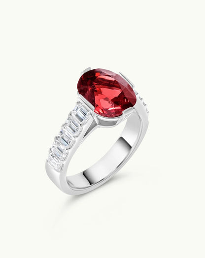 Detalle de anillo oval rojo fancy con diamantes laterales baguette en oro