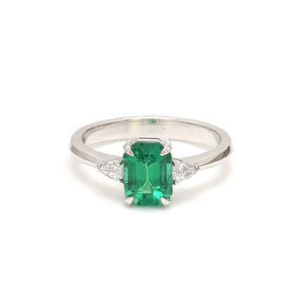 Anillo solitario con esmeralda de laboratorio y diamantes laterales — Amelia Maia.